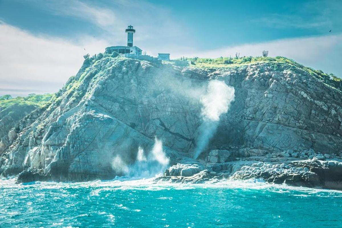 un faro in cima a una scogliera con un'onda