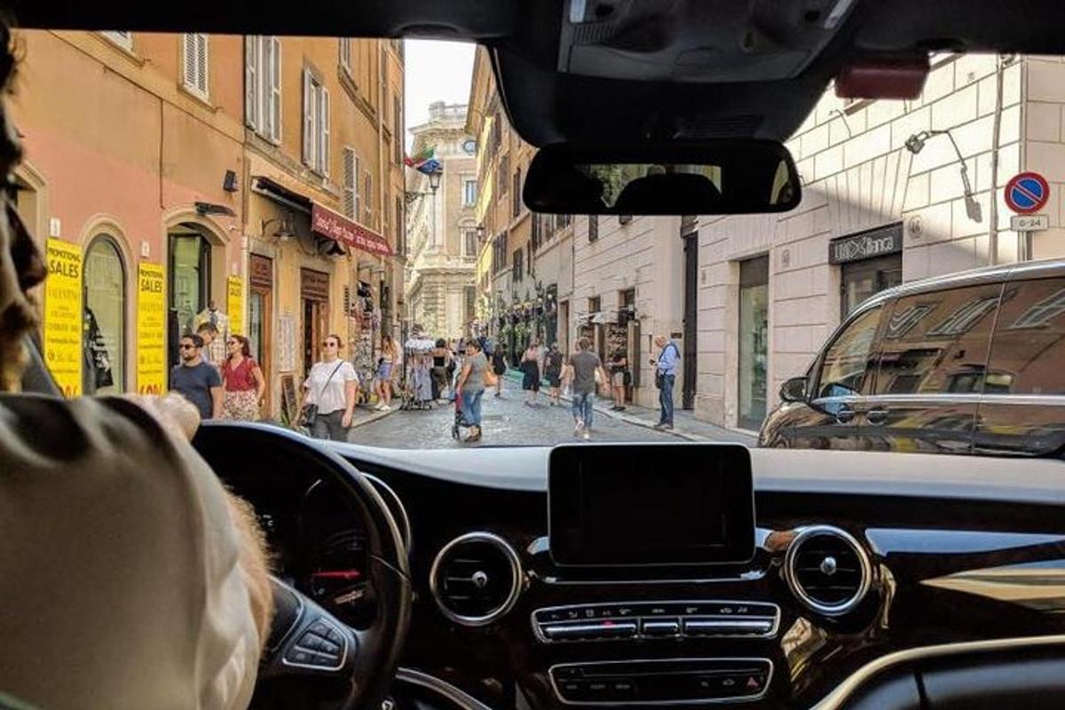 una persona che guida un'auto lungo una strada cittadina