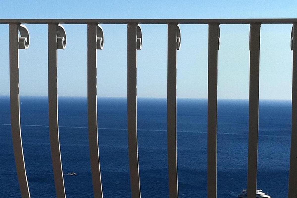 una vista sull'oceano da un balcone con una recinzione