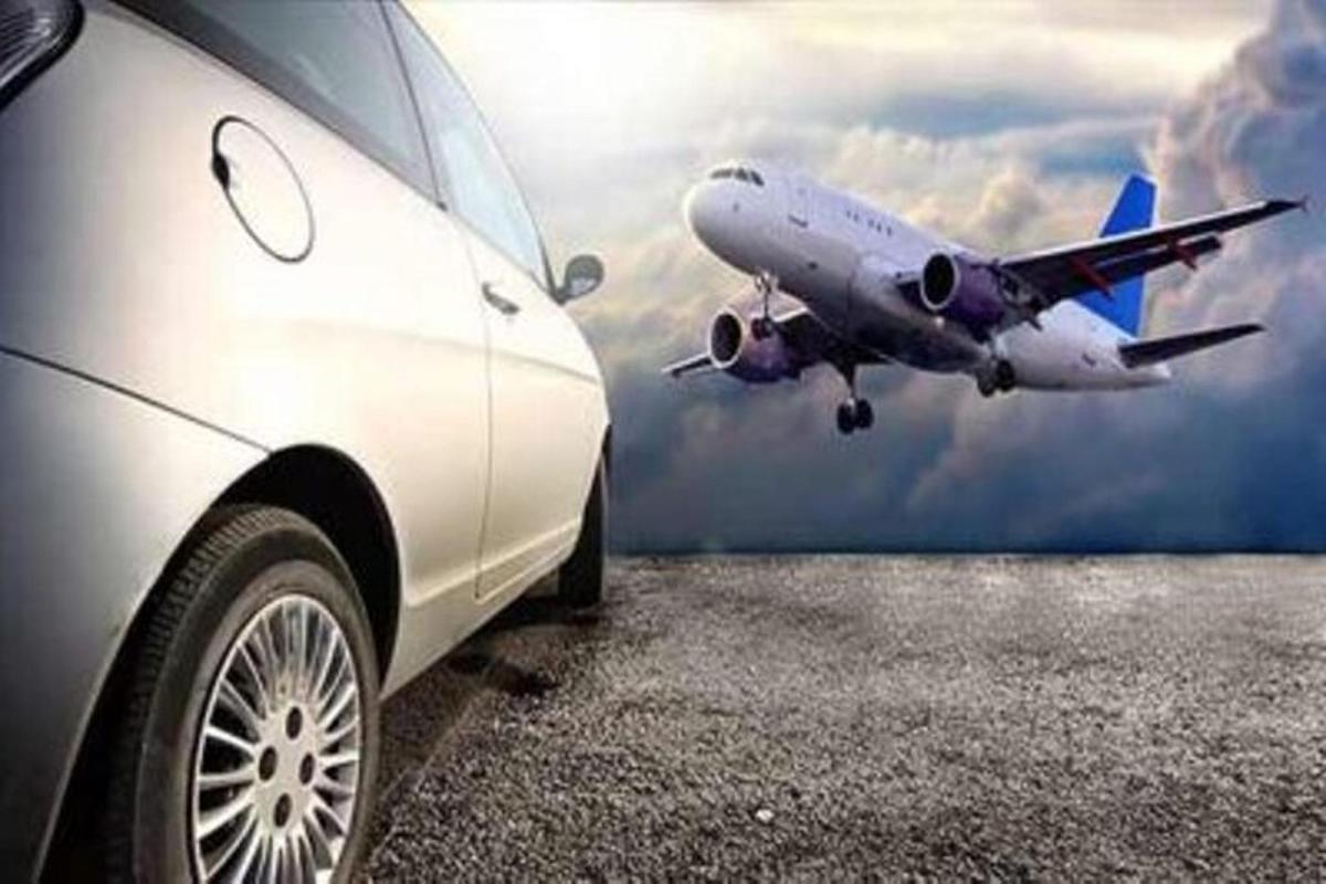 auto zaparkované vedľa lietadla letiaceho na oblohe