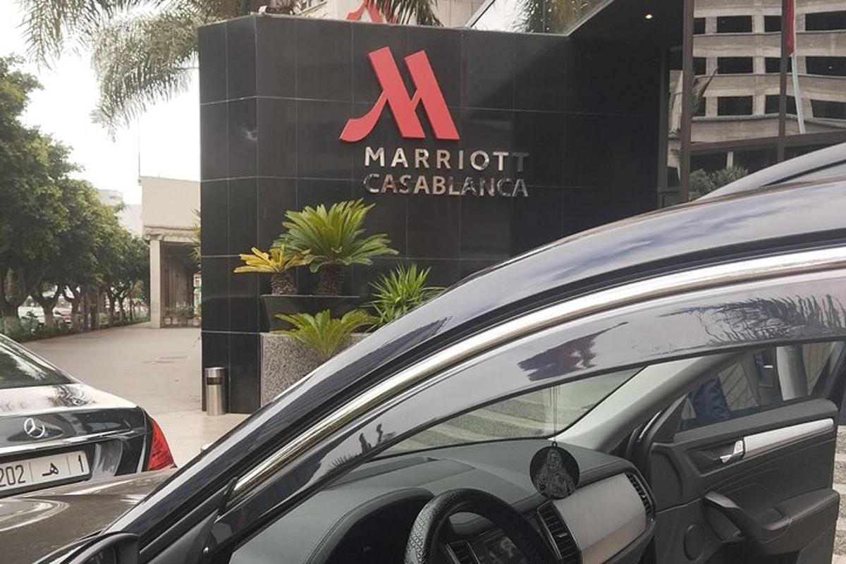 uma placa de uma concessionária de carros Marriott com carros estacionados do lado de fora