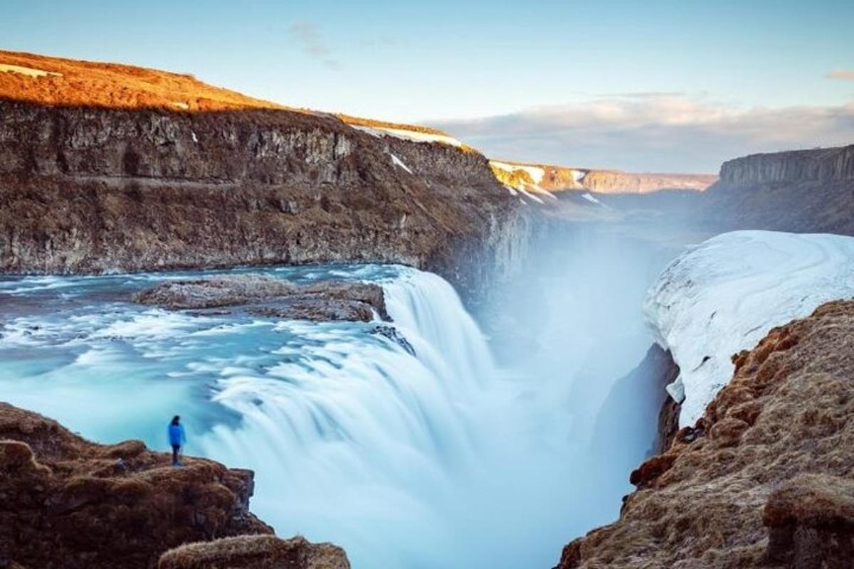 un uomo in piedi davanti a una cascata
