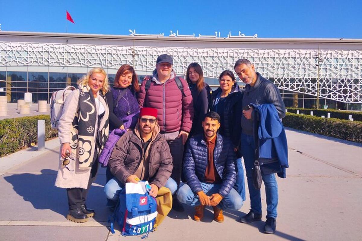 een groep mensen die poseren voor een foto voor een gebouw