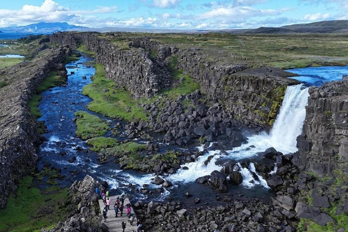 un gruppo di persone in piedi accanto a una cascata