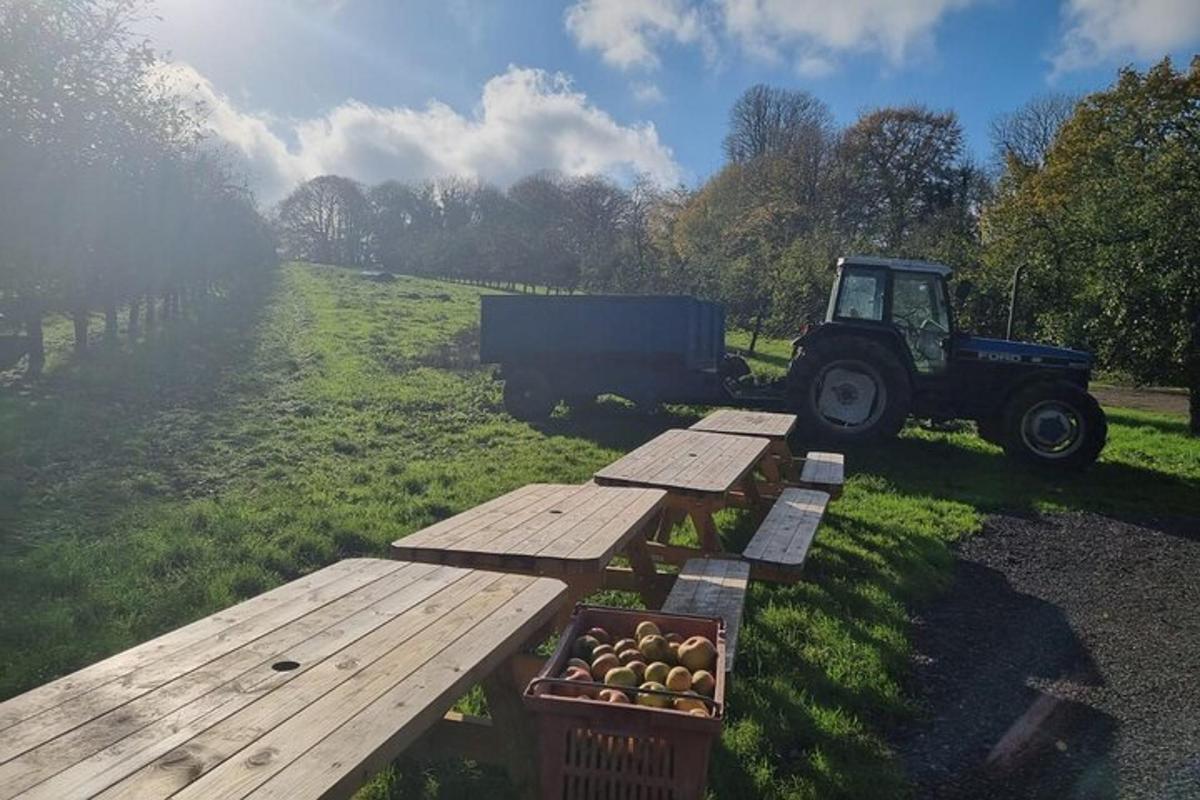 a tractor parked next to a table and a crate of apples