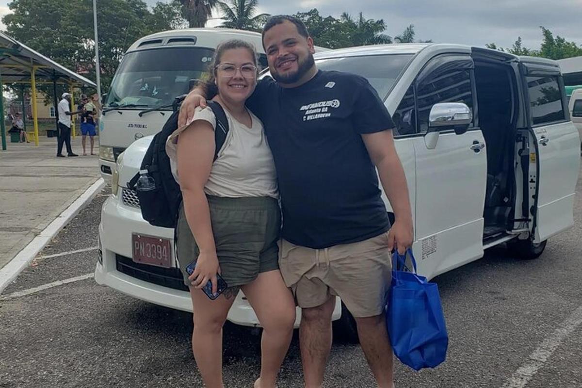 seorang pria dan seorang wanita berdiri di samping sebuah mobil van