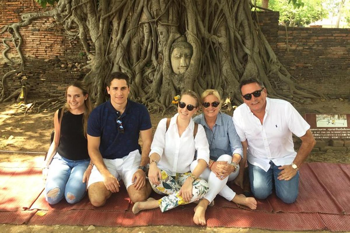 a group of people sitting in front of a tree
