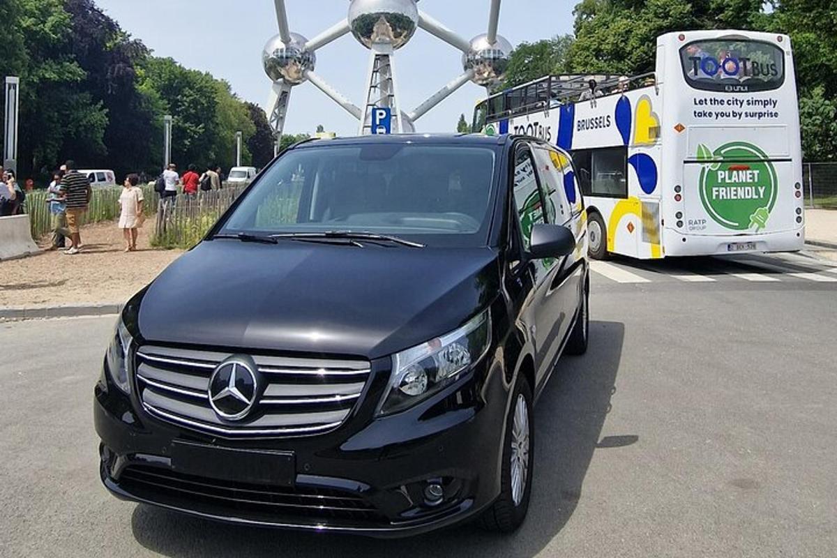 a black car parked next to a bus