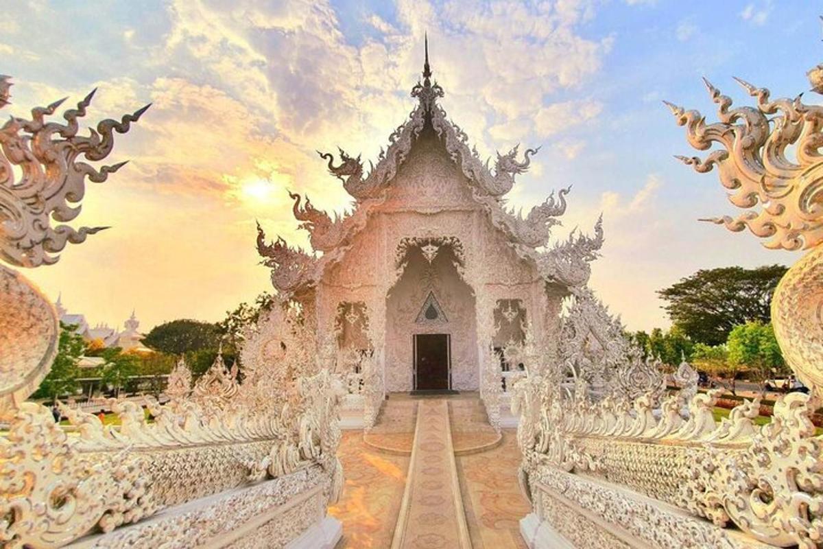 ein weißer Tempel mit einem Sonnenuntergang im Hintergrund