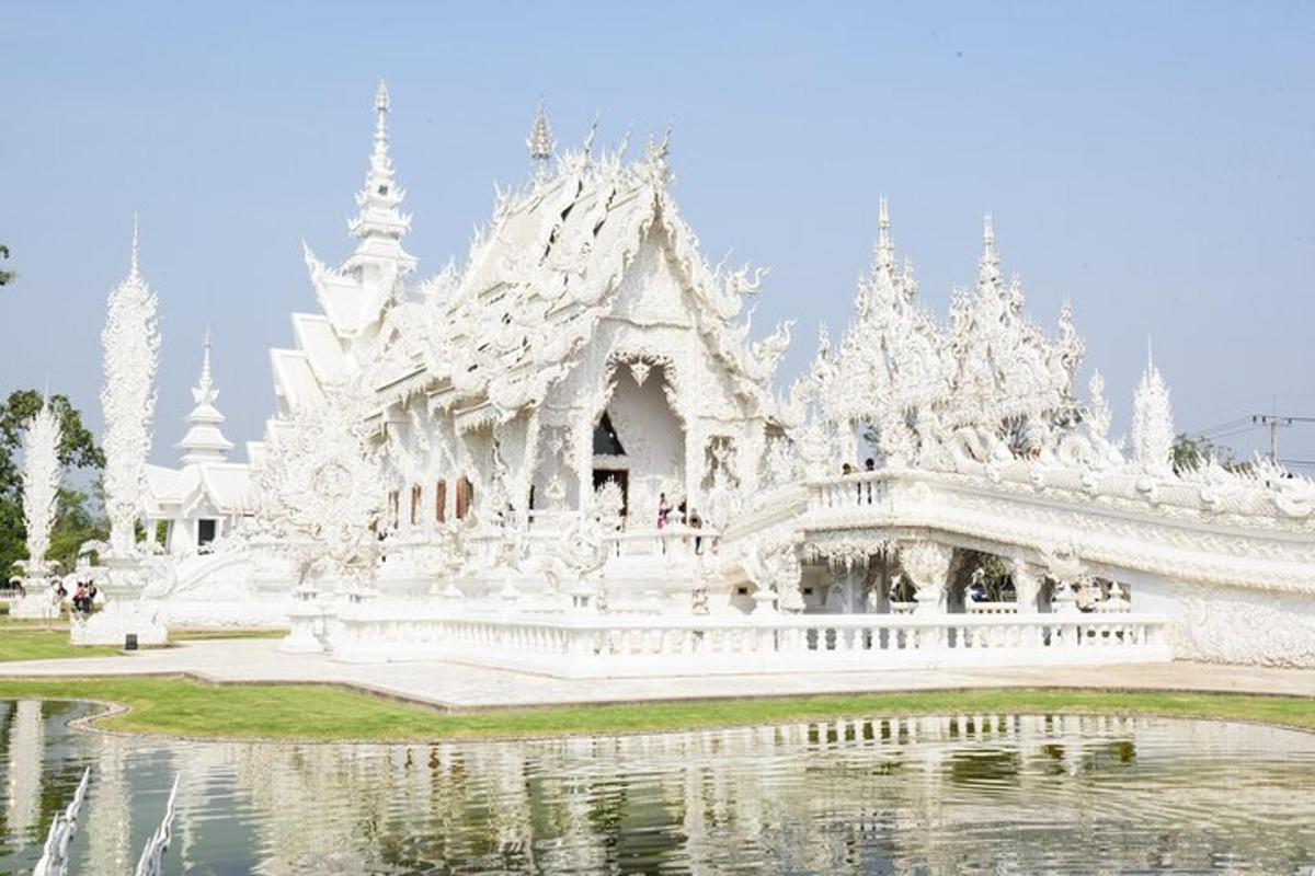 ein weißer Tempel mit einem Teich davor
