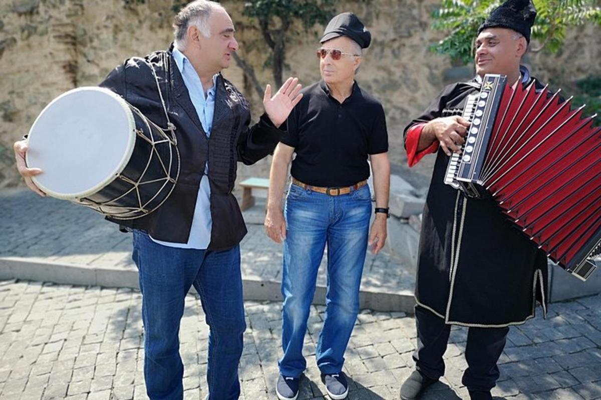 egy három férfiból álló csoport egy harmonika mellett áll