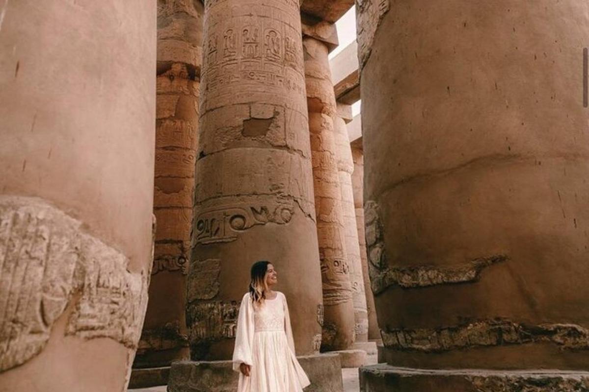 eine Frau in einem weißen Kleid steht vor Säulen