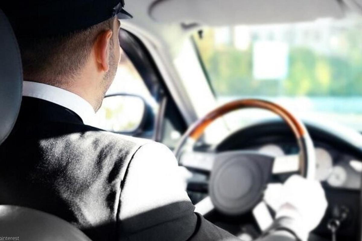 a man driving a car with a steering wheel