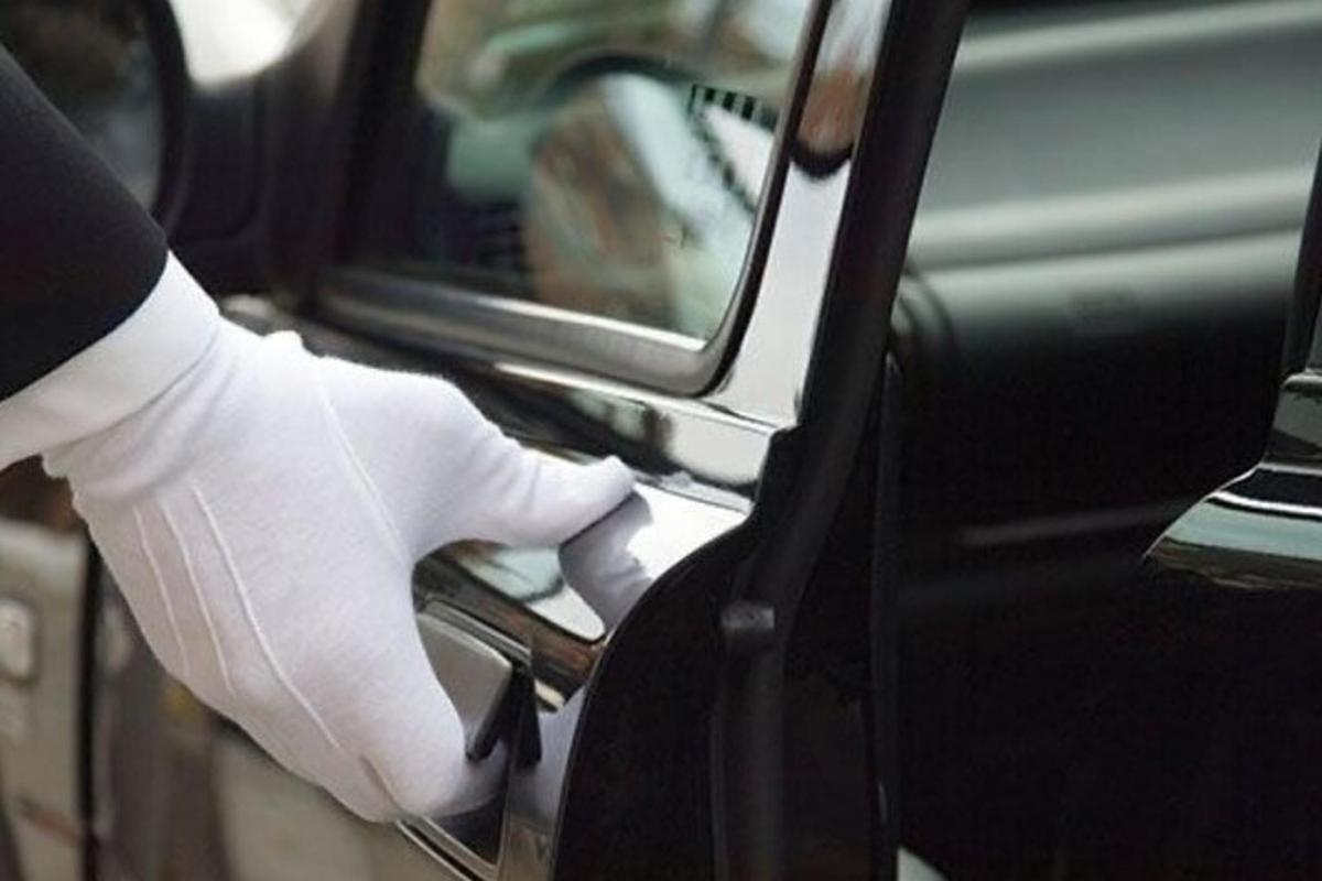a person in a white glove unlocking a car door