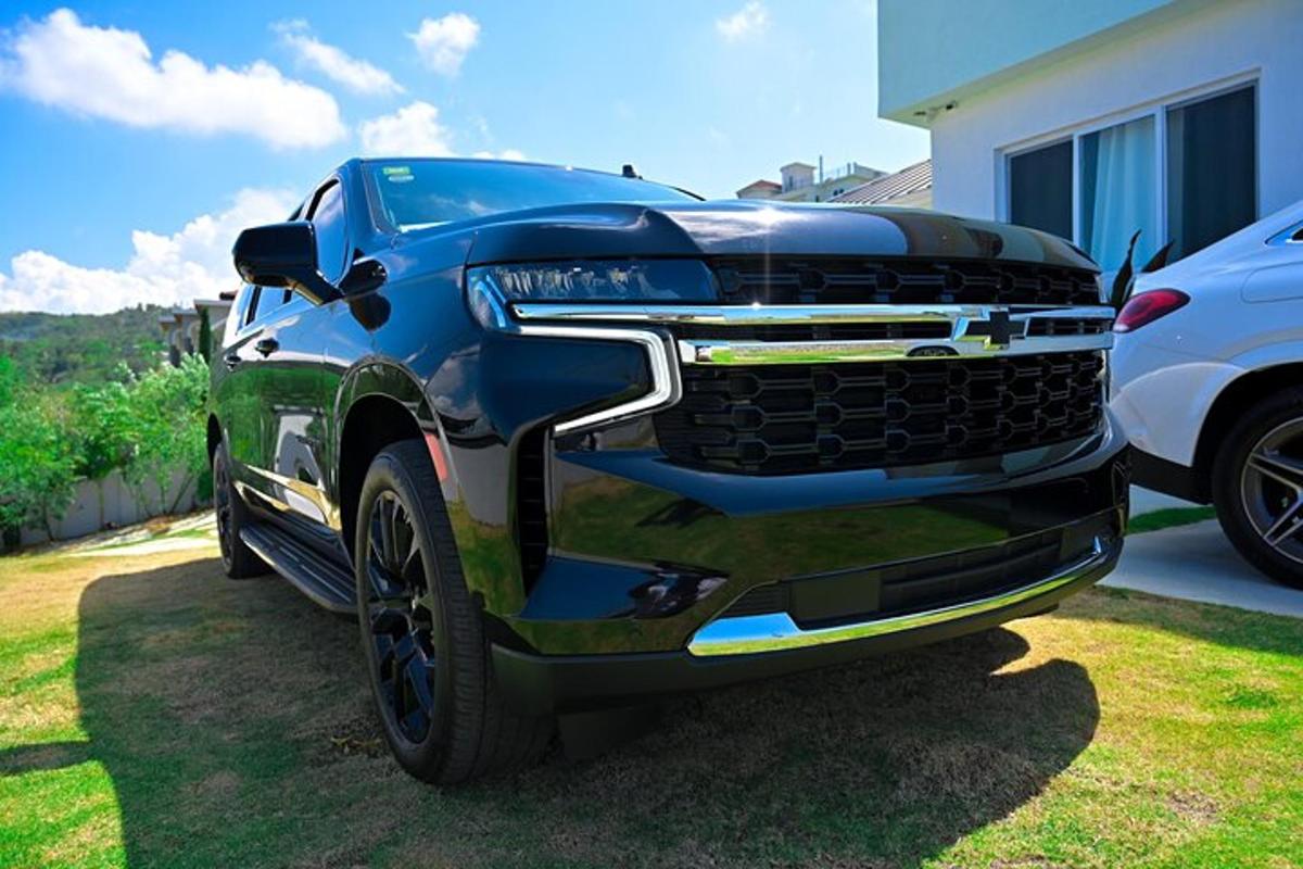 truk biru diparkir di halaman di samping mobil