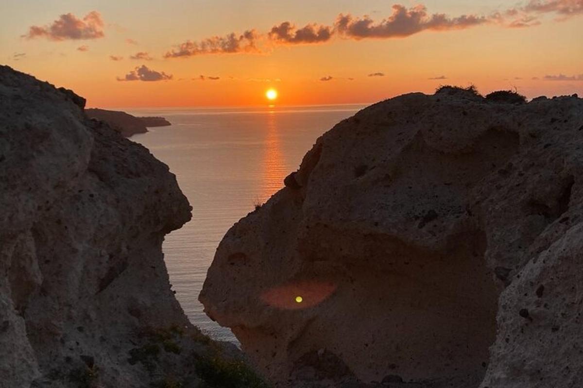 Západ slunce nad oceánem mezi dvěma velkými skalami