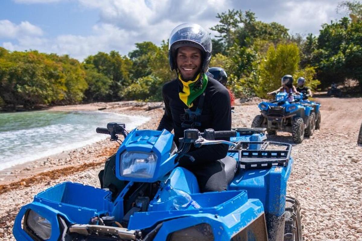 a man sitting on a blue atv on a beach