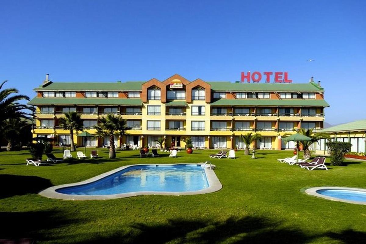 a hotel with a swimming pool in front of it