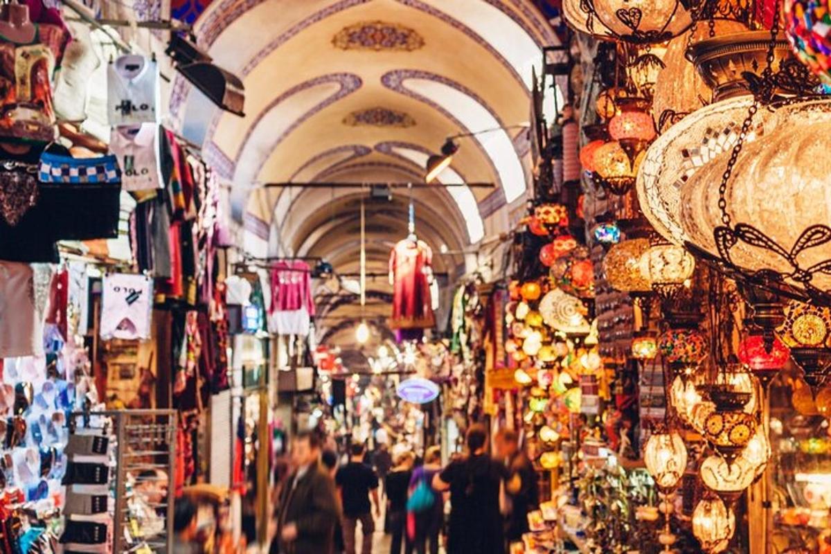 a crowd of people walking through a market with shops