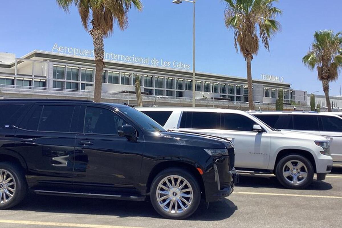 Dos coches estacionados en un estacionamiento frente a un edificio.