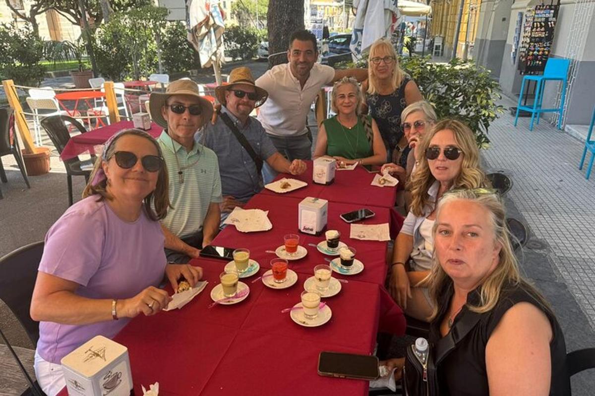 un gruppo di persone sedute attorno a un tavolo con dei cupcake