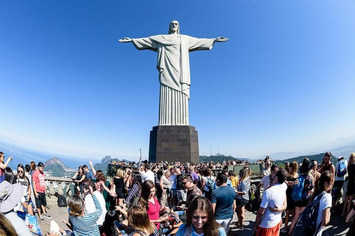 una folla di persone in piedi attorno alla statua del Cristo Redentore