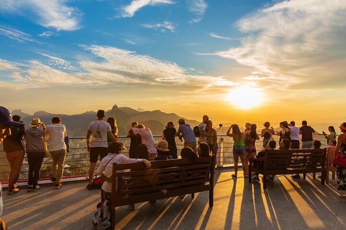 un gruppo di persone in piedi su un ponte che guarda il tramonto
