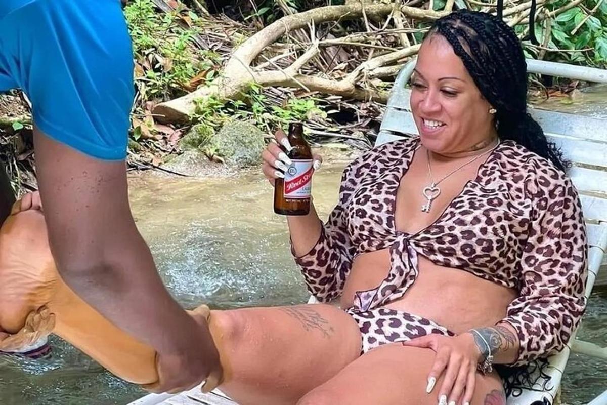 seorang wanita duduk di dalam air sambil memegang bir