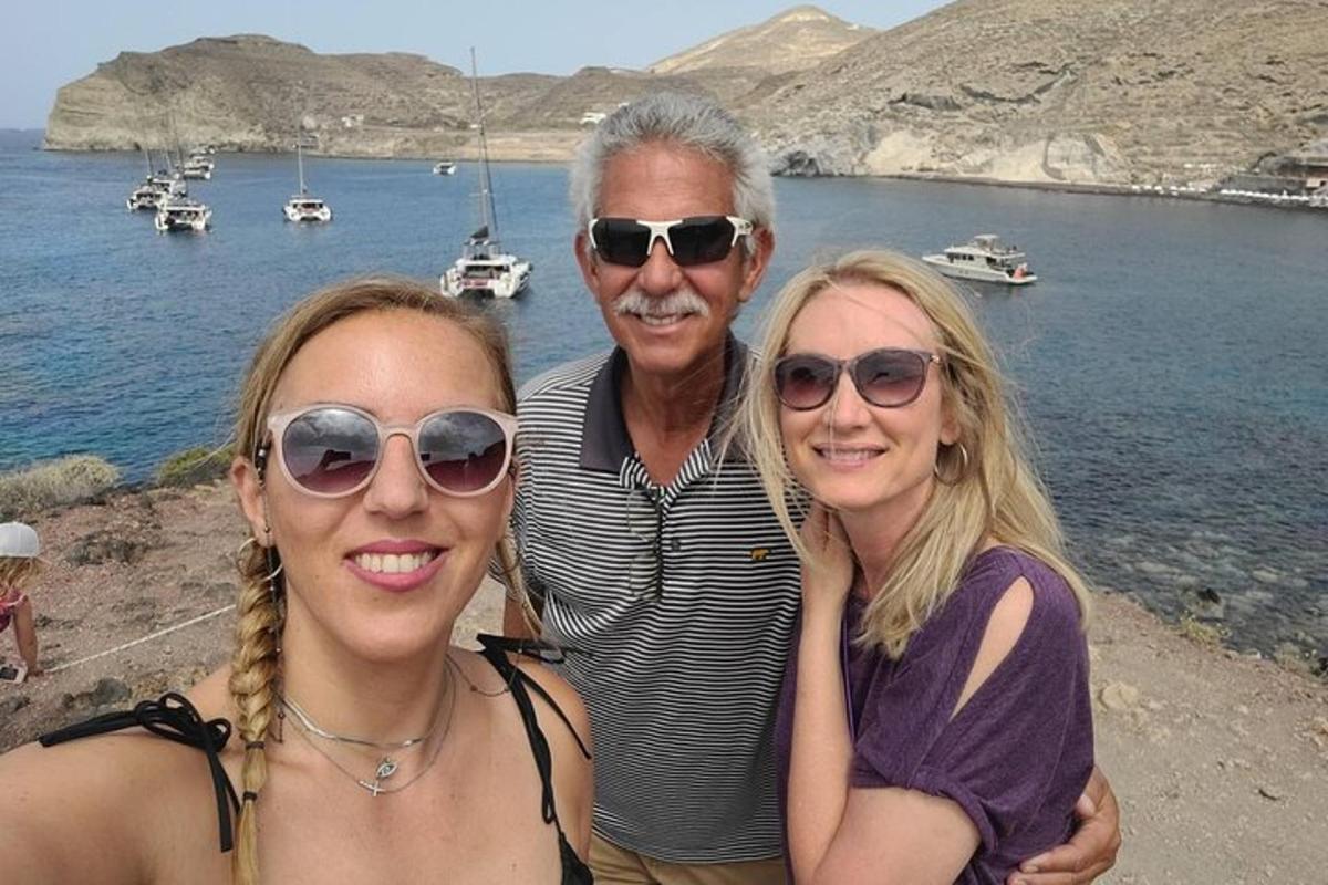 Un hombre y dos mujeres de pie junto al agua.