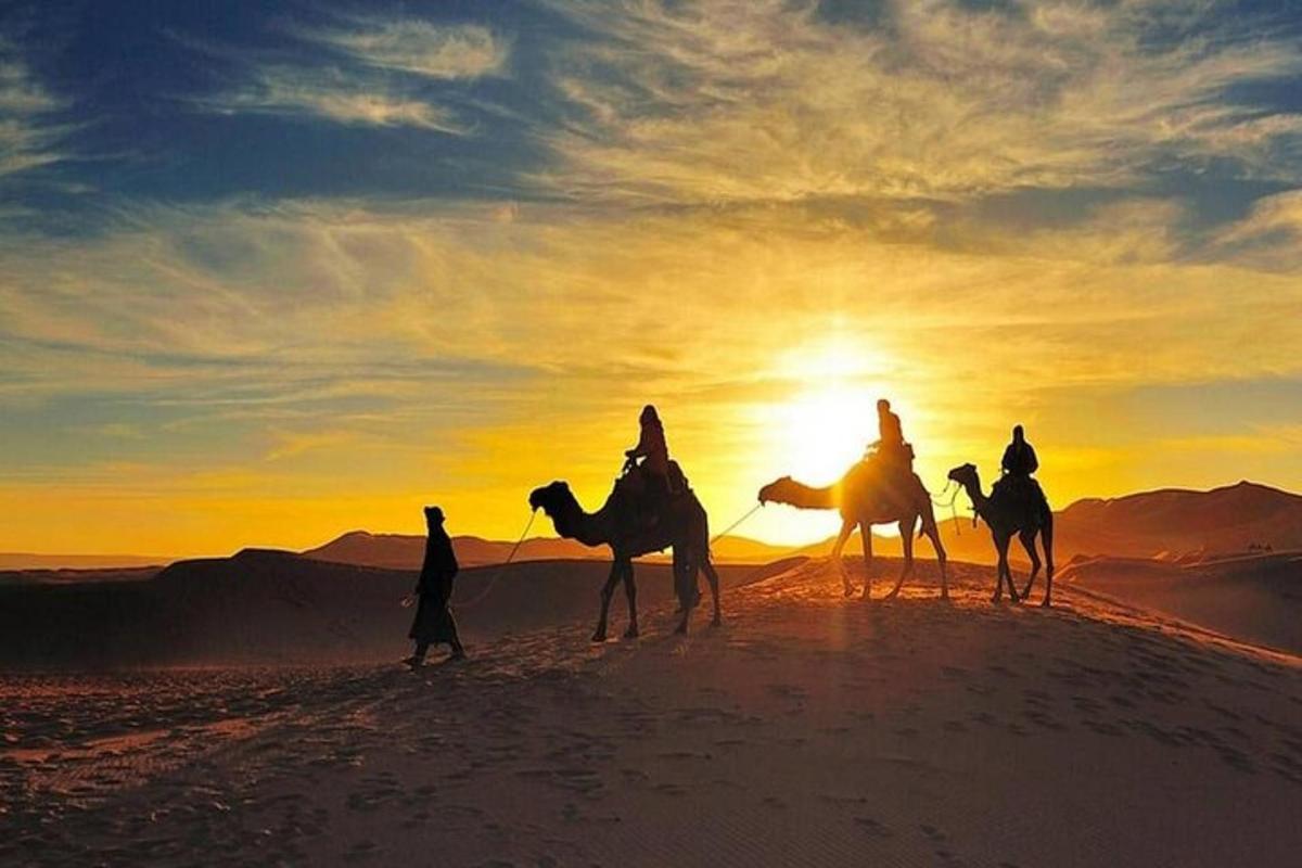 um grupo de pessoas andando de camelo no deserto