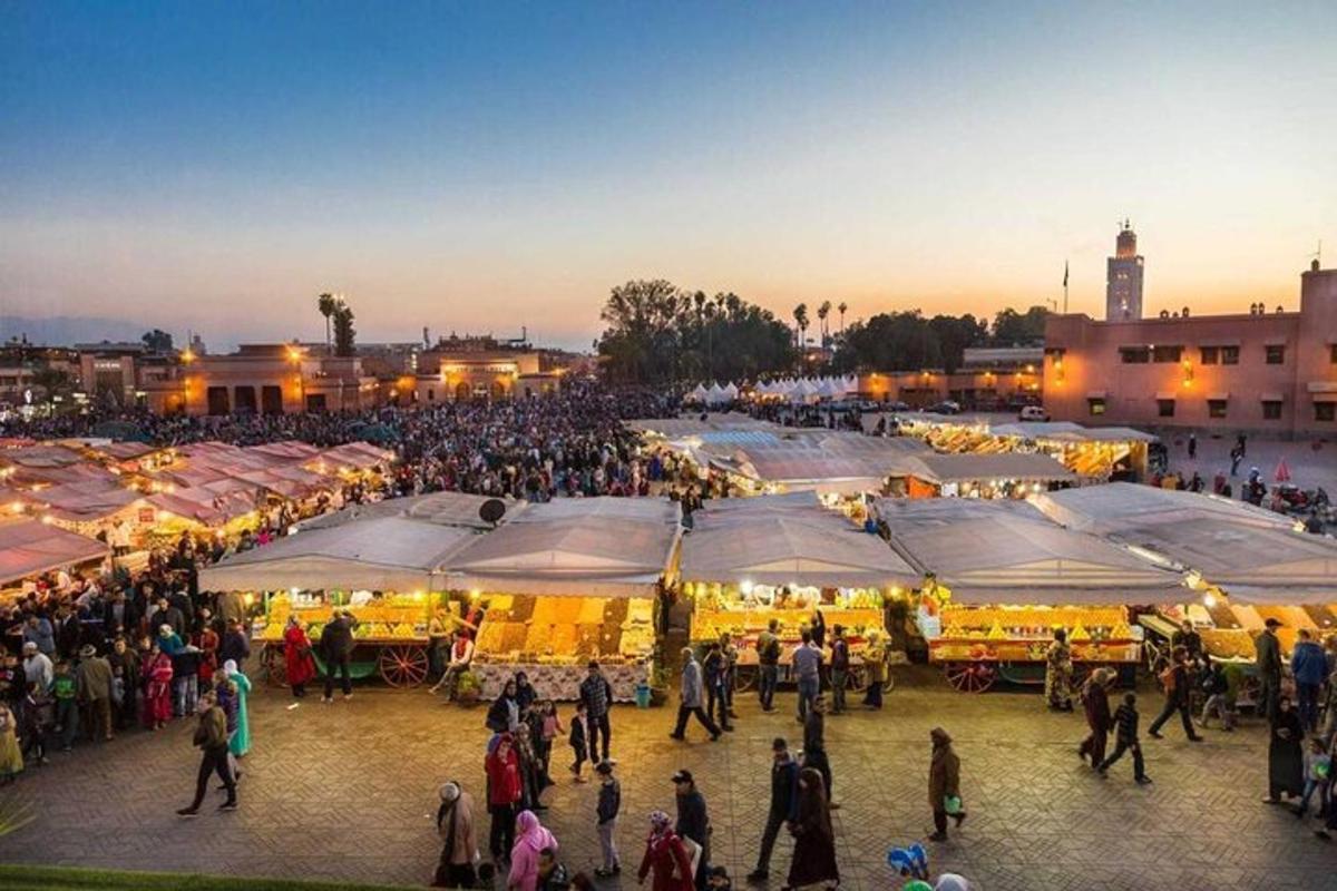 a crowd of people walking around a market with tents
