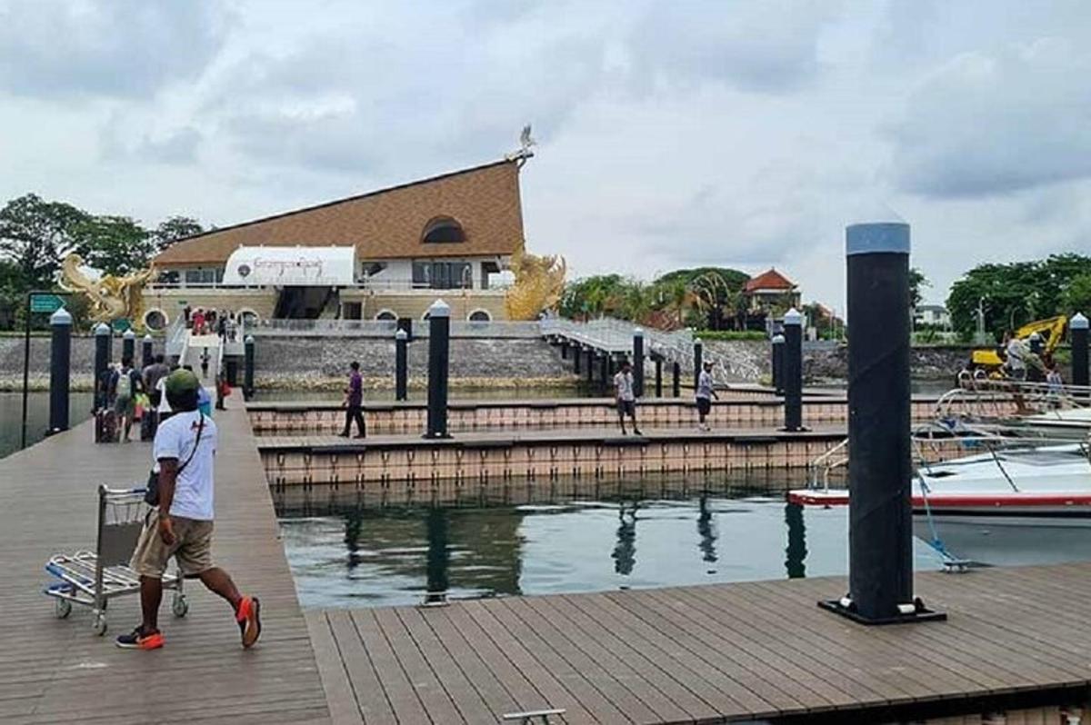 a man walking on a pier next to the water