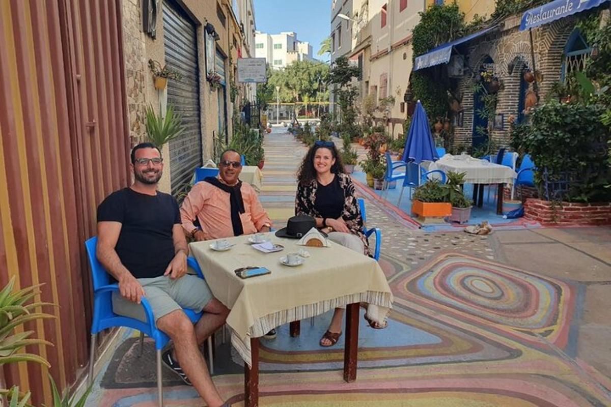 μια ομάδα ανθρώπων που κάθονται σε ένα τραπέζι σε έναν δρόμο