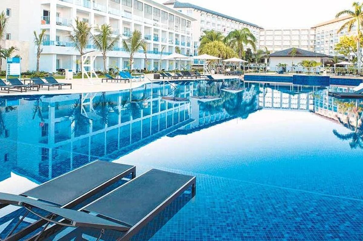 una grande piscina con sedie e un hotel
