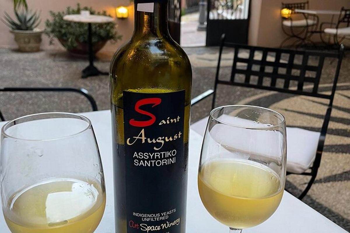uma garrafa de vinho ao lado de duas taças em uma mesa