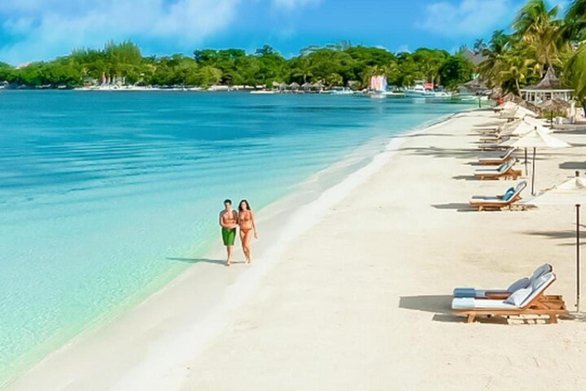 dua orang berjalan di pantai di dalam air