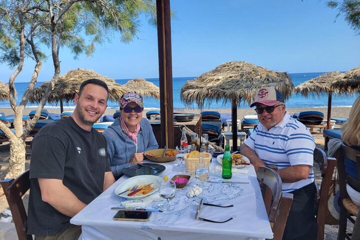 um grupo de pessoas sentadas à mesa na praia