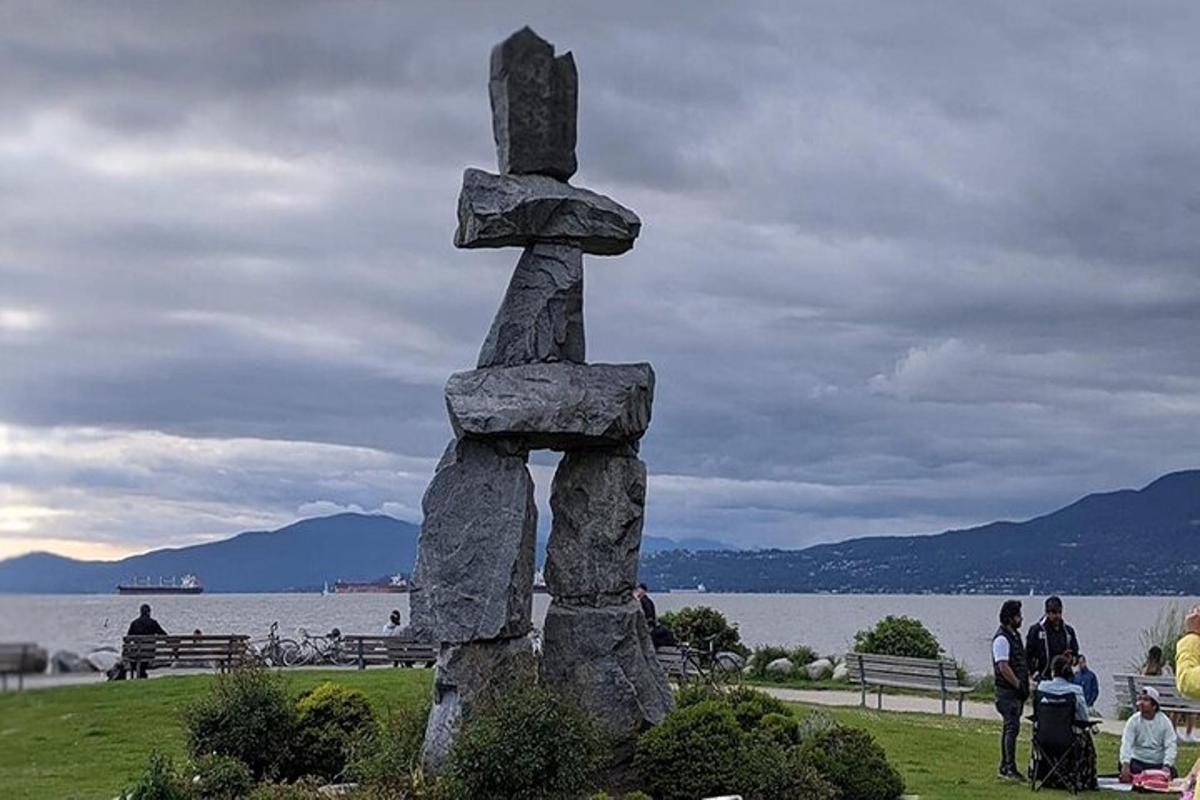 a stone statue in front of a body of water