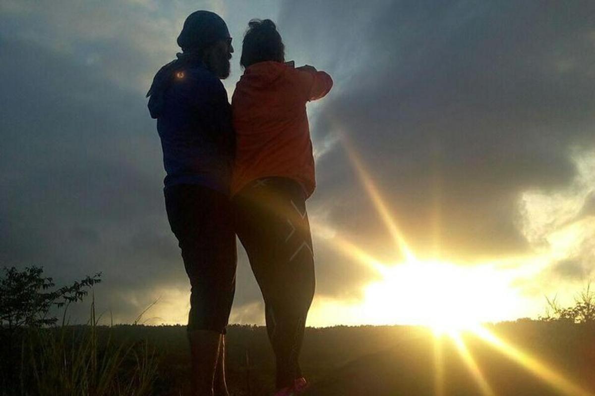 a man and woman standing in front of the sun