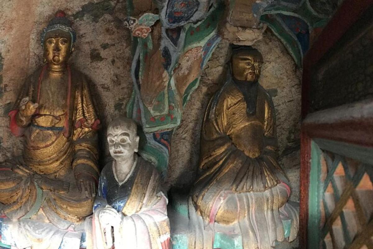 un gruppo di statue sedute in una grotta