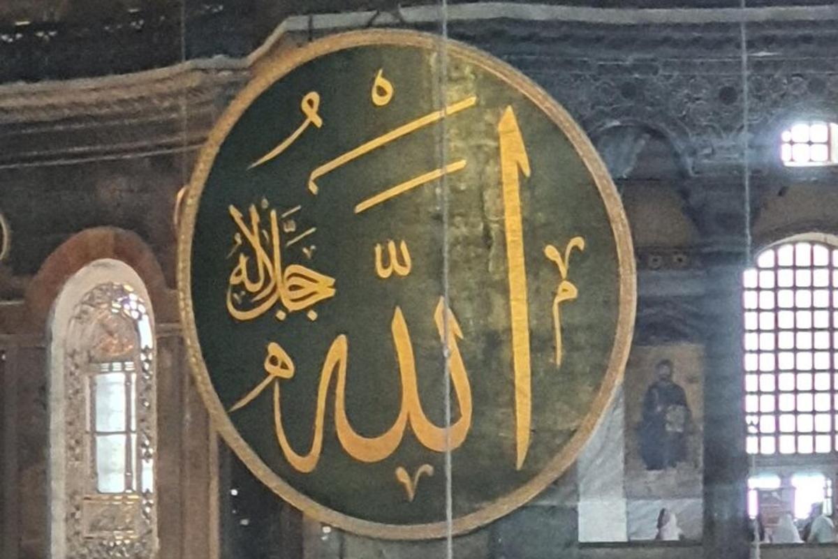 Un reloj con escritura árabe en un edificio.