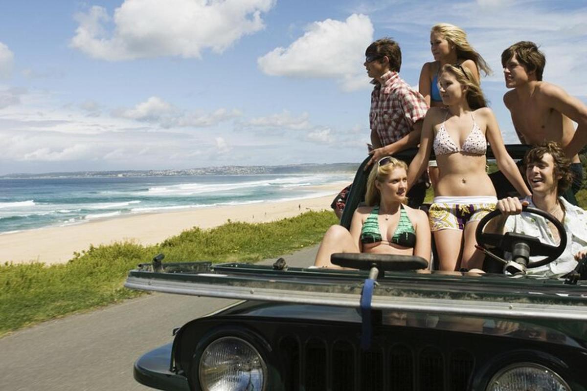 un grup de persones a la part posterior d'un jeep a la platja