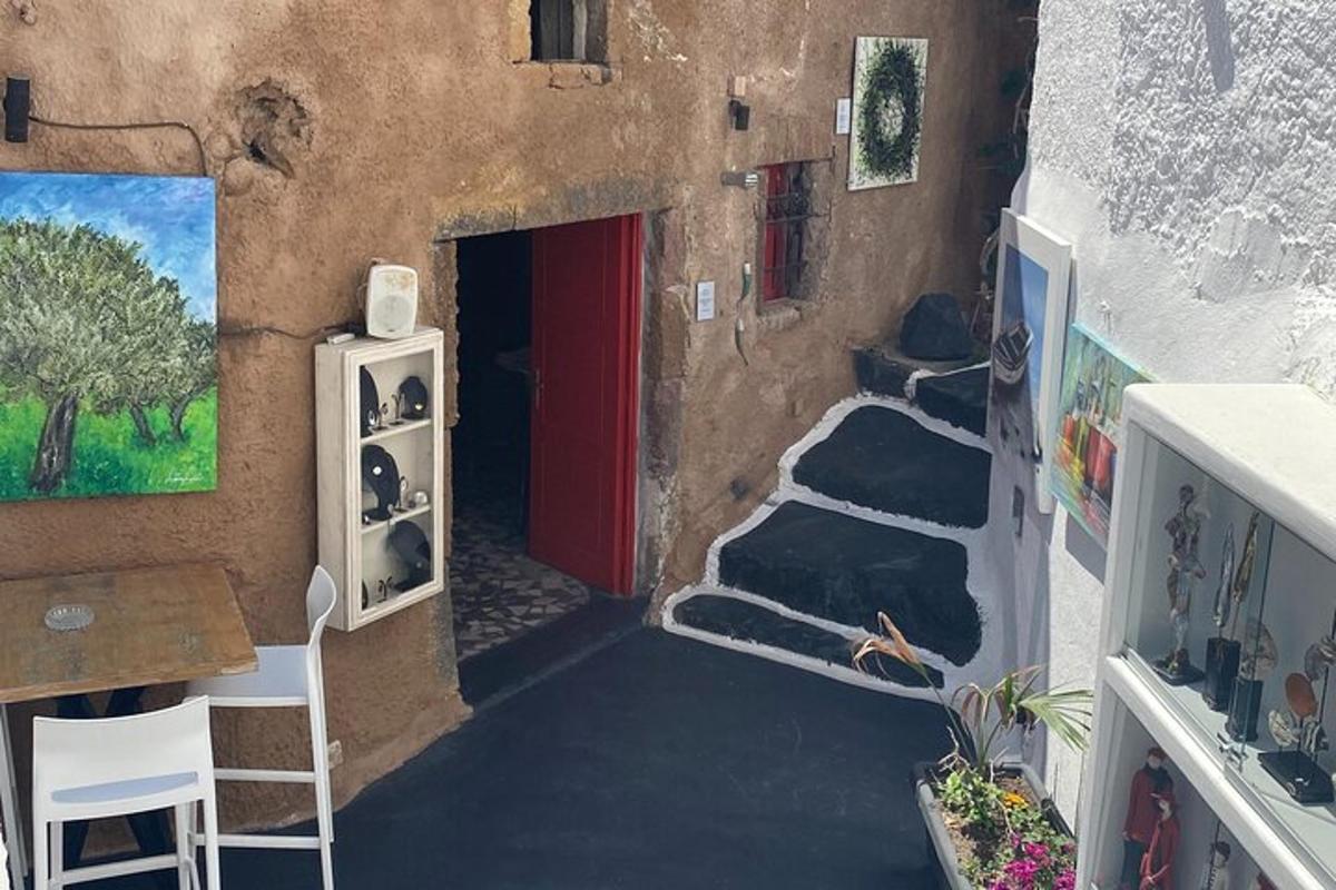 Una habitación con una pintura de una casa con una puerta roja.