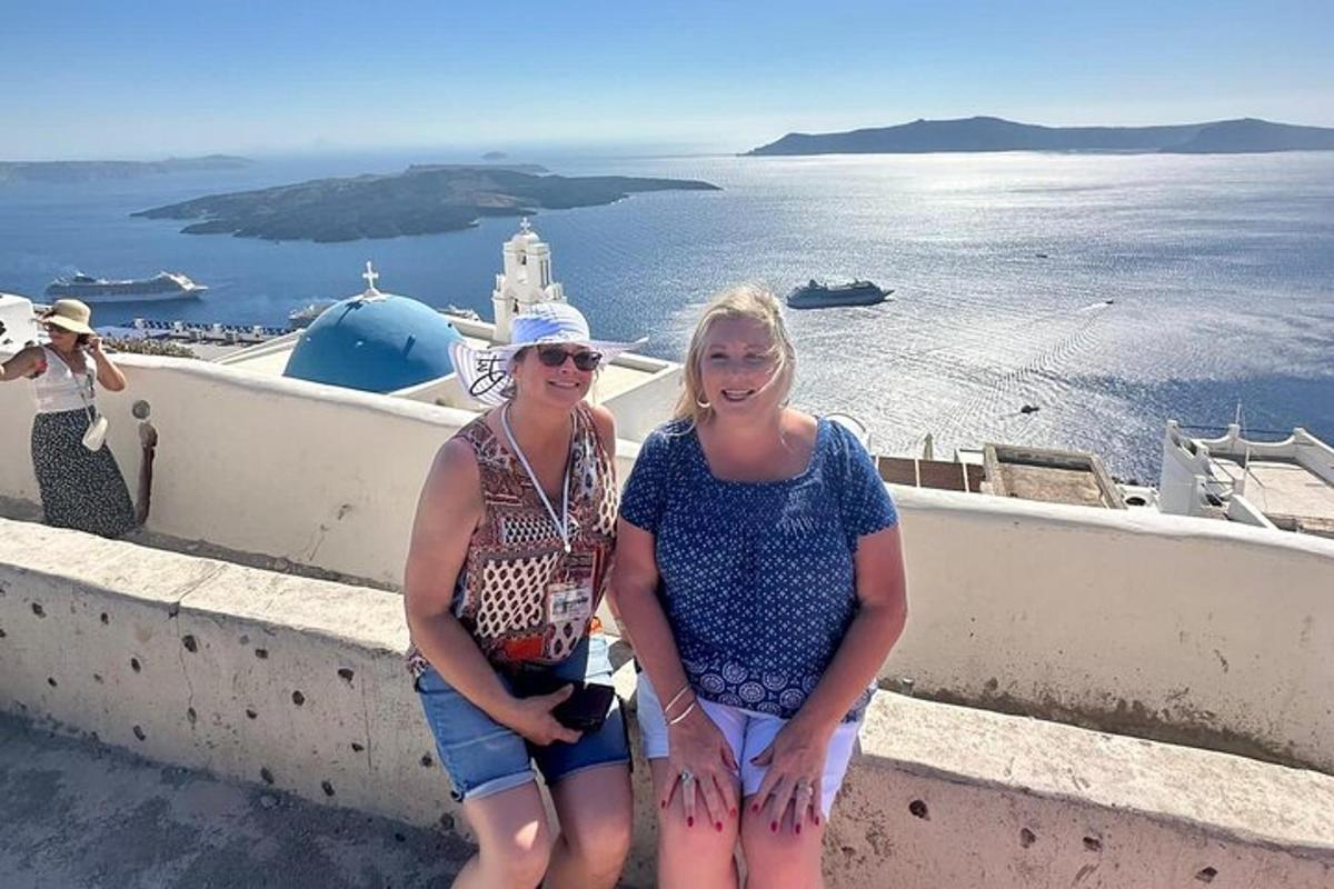 duas mulheres em pé em uma saliência olhando para o oceano