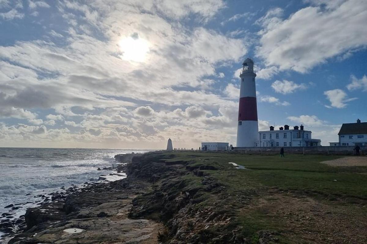 a red and white lighthouse on the shore of the ocean