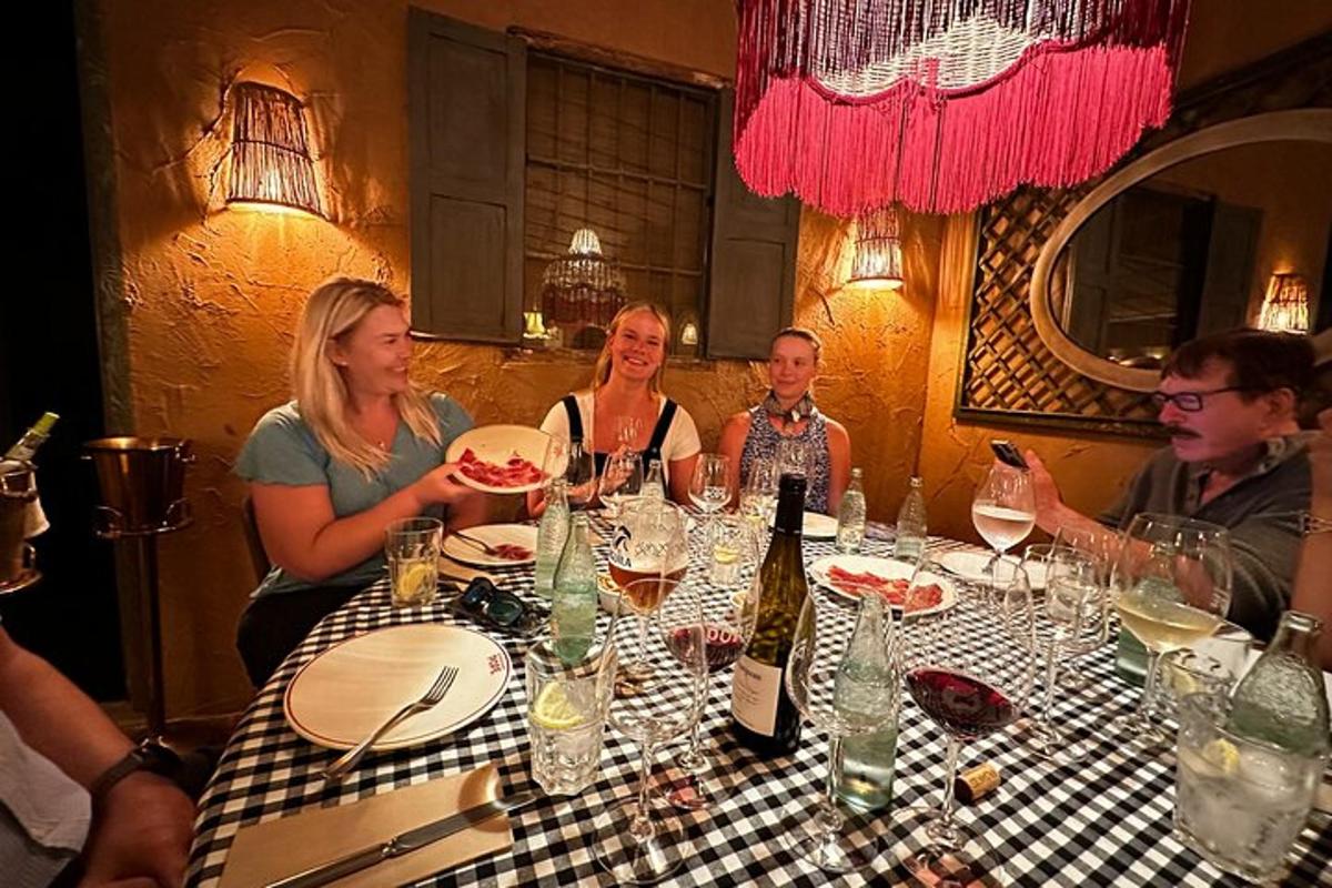 un gruppo di persone sedute attorno a un tavolo con bicchieri di vino