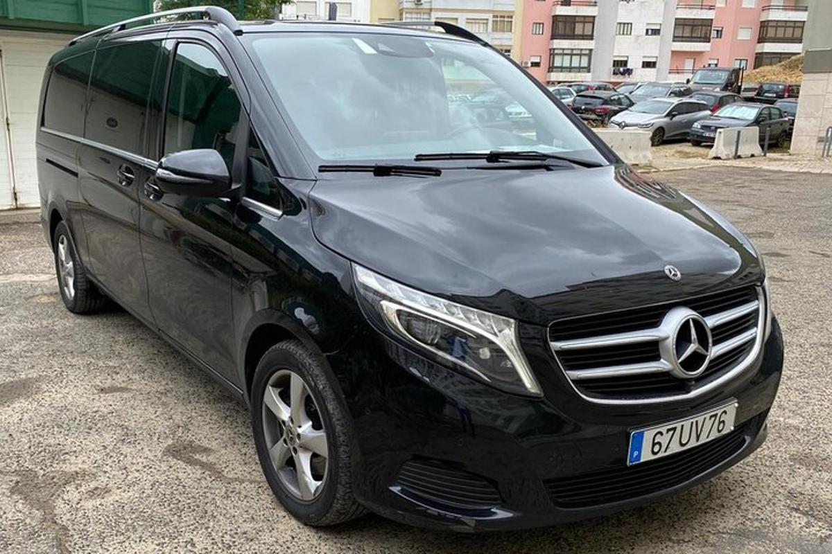 en svart varebil parkert på en parkeringsplass