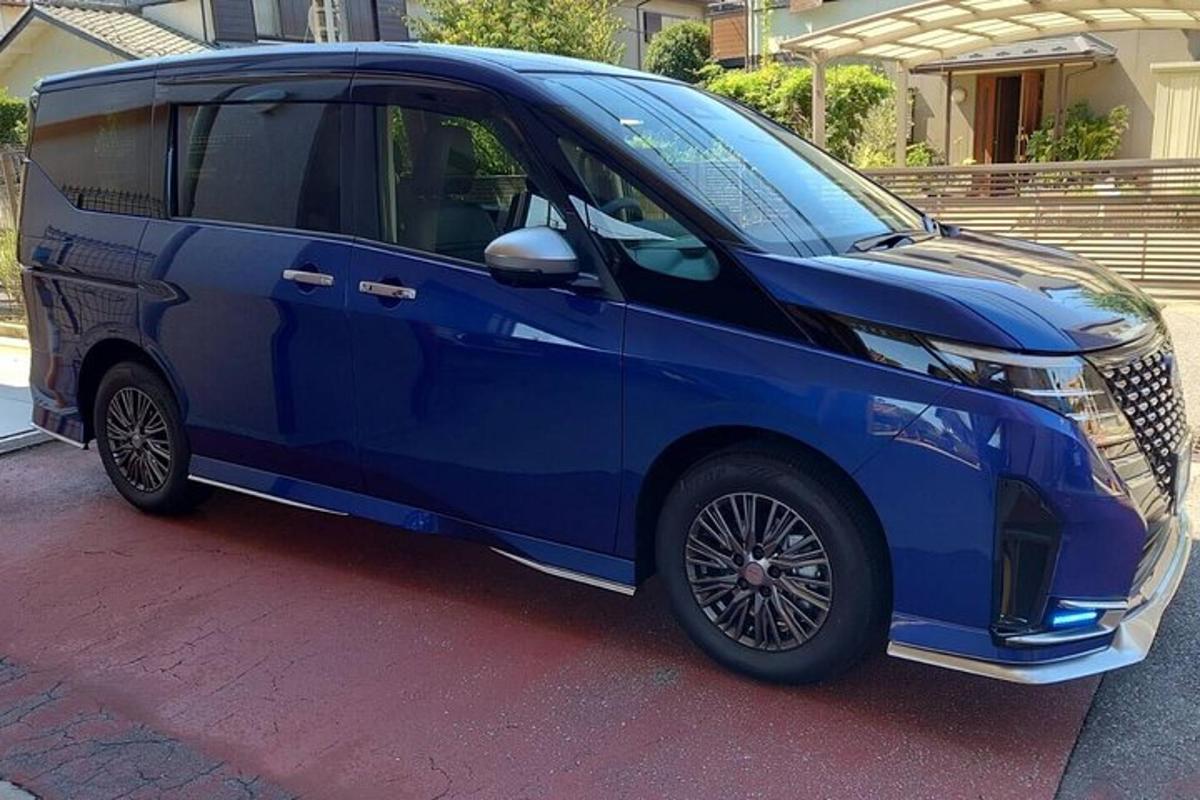 sebuah mobil biru terparkir di depan sebuah rumah