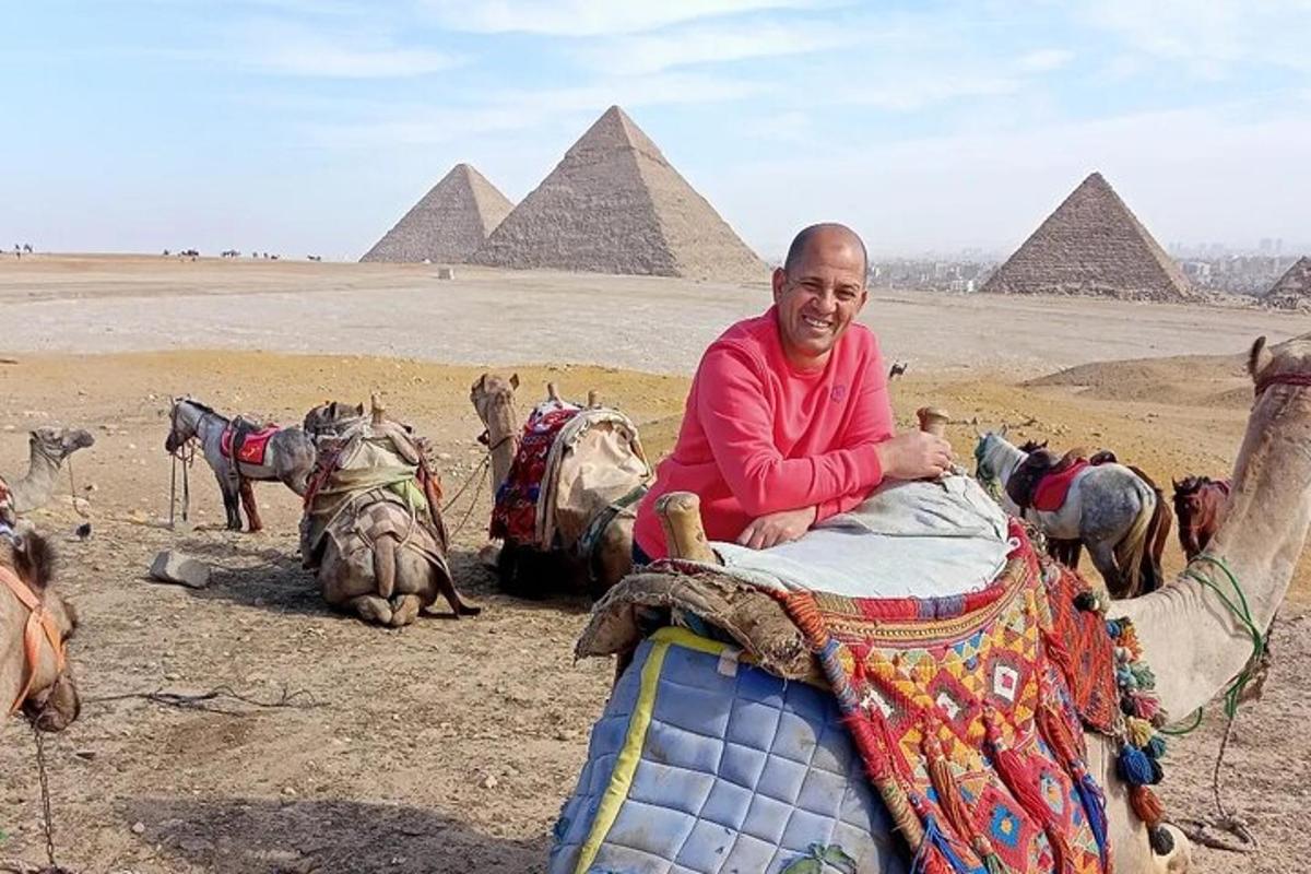 Ein Mann sitzt auf einem Kamel vor Pyramiden