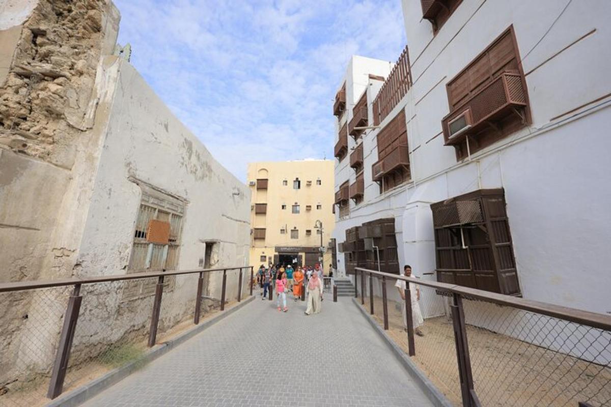 a group of people walking down a street next to buildings